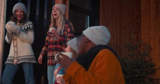Positive Emotionen. Fröhliche Freunde lächeln und lachen bei heißen Getränken auf der Winterterrasse in Zeitlupe. — Stockvideo