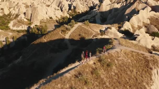 Vacker antenn skott av lycklig familj med barn vandring längs vägen på toppen av soluppgången berget njuta av Cappadocia utsikt. — Stockvideo