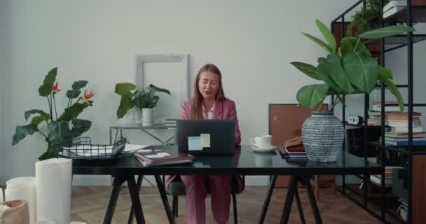 Web konferansı konsepti. Güzel, mutlu iş kadını ofis masasında bilgisayarla çalışan ortaklarla konuşuyor.. — Stok video