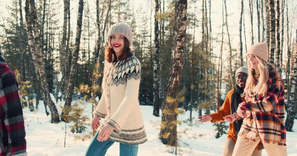 Enjoying winter holiday. Happy fun diverse friends walk along magnificent deep snow forest path together slow motion. — Stock Photo, Image