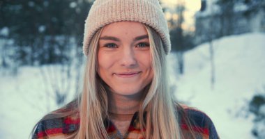 Kışın tadını çıkarıyorum. Mutlu, genç, güzel, 20 'li yaşlarda, melez bir kadın kameraya gülümsüyor karlı ormanda ağır çekimde..