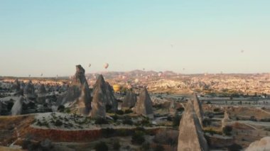 26 Temmuz 2021 CAPPADOCIA, TURKEY İHA gökyüzünde uçan renkli hava balonlarından büyük kayalara iniyor..