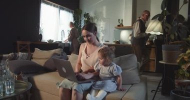 İnternetten alışveriş çok rahat. Küçük kızıyla birlikte dizüstü bilgisayar kullanan mutlu güzel kadını büyük oturma odasında yakınlaştır..