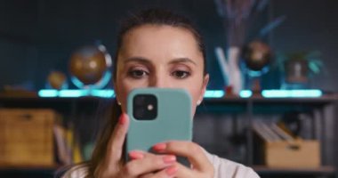 Mutlu kadın blogcu akıllı telefondan harika haberler okuyor, şaşırıyor, şaşırıyor ve heyecanlanıyor..