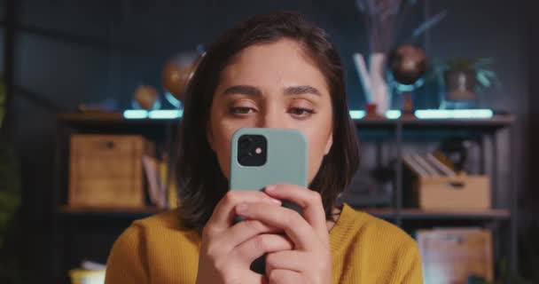 ΑΝΤΙΔΡΑΣΗ ΣΤΗ ΜΕΓΑΛΗ ΕΠΙΤΥΧΙΑ Ευτυχισμένη όμορφη νεαρή ισπανόφωνη γυναίκα διαβάζει τα νέα smartphone, εκπλήσσεται από την ξαφνική επική νίκη. — Αρχείο Βίντεο