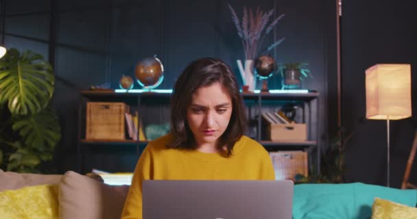 РАБОТА ONLINE Красивая счастливая молодая ориентированная латиноамериканская бизнес-женщина, использующая ноутбук для работы из дома в уютной гостиной. — стоковое видео