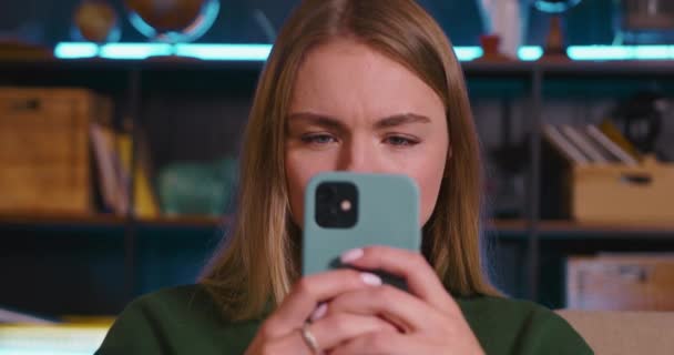 Glad attraktiv ung 20-tals blond kvinna läser goda nyheter på mobiltelefon, tittar på kameran blir förvånad och förvånad. — Stockvideo