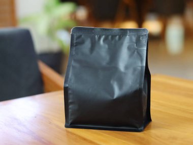 Kafe masasındaki ayakta duran kahve torbası ambalajının fotoğrafı. Yapıştırma etiketleri, kahve varyantı ambalaj etiketleri veya benzeri şeyler için uygun.