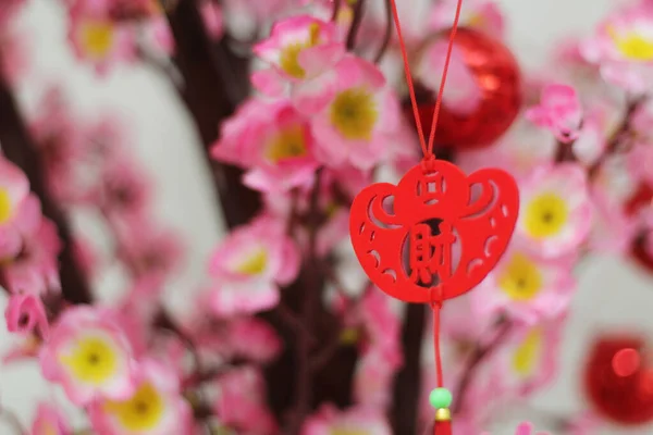Pink Cherry Blossoms with Chinese ornaments on a blur cafe background