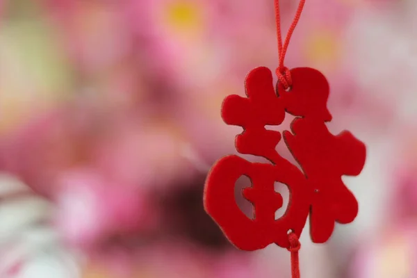 Pink Cherry Blossoms with Chinese ornaments on a blur cafe background