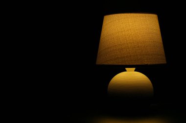 Gece lambası, gece yatağın yanında bir lamba sıcaklık ve ev konforu hissi yaratacaktır. Siyah arkaplanda lamba