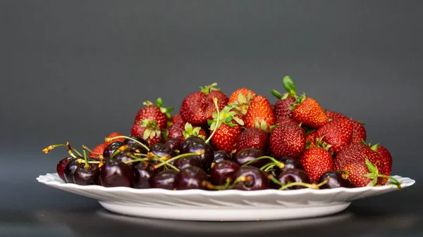 plate with berries on a black background