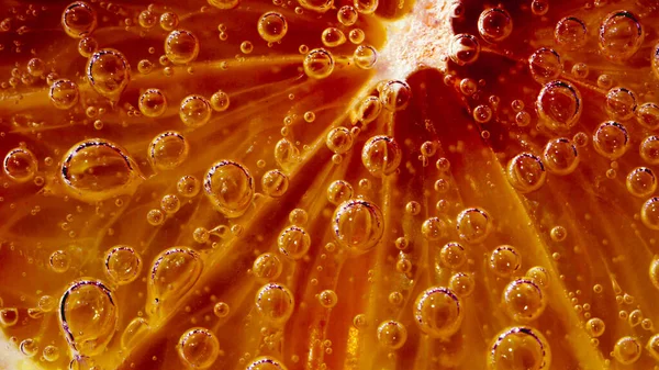 a orange in soda with bubbles, sparkling water