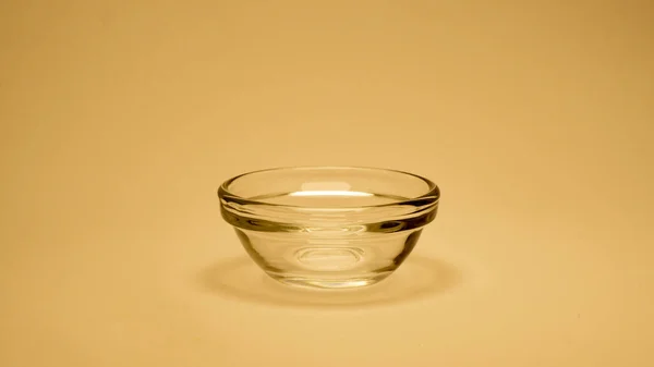 黄色の背景に空のガラスカップ — ストック写真