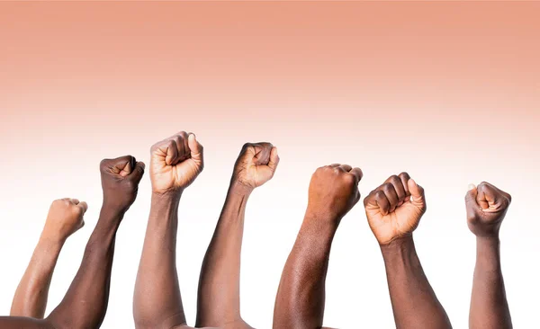 Raised hands of african american men clenched into fists on light background. Stop racism concept