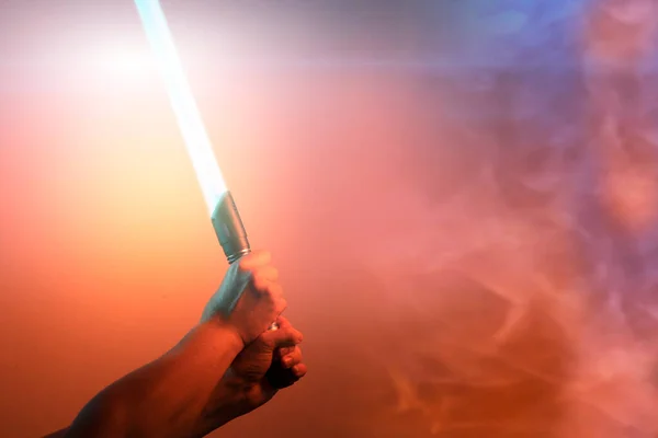 a fantastic laser sword lightsaber in the hands of a man