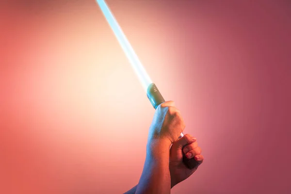 a fantastic laser sword lightsaber in the hands of a man