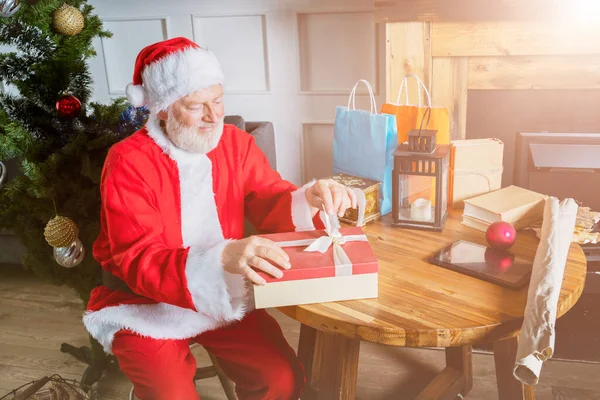 Santa Claus prepares gifts box for Christmas portrait