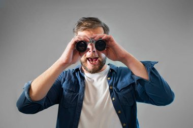 Genç bir adam dürbün resmine bakar.