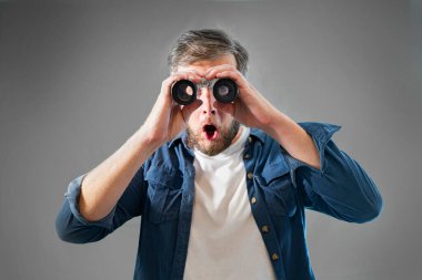 Genç bir adam dürbün resmine bakar.