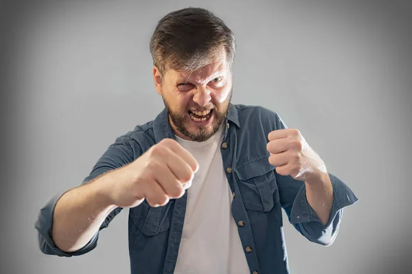 a young man angry and waves his fists portrait