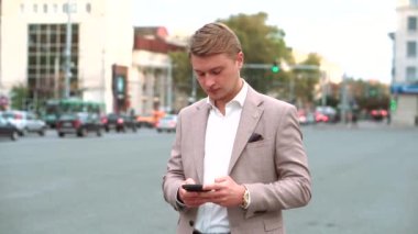 Şehirdeki yakışıklı delikanlının telefonda bir mesaj yazdığı görüntüler.