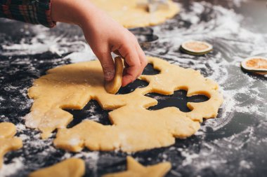 Çocuk eli, un dolu bir masada yaptığı zencefilli ekmeği alıyor..