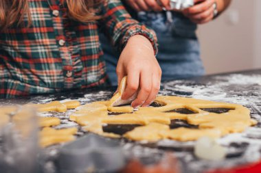 Genç kız, annesiyle evde çok güzel zencefilli ekmek şekilleri kesiyor..
