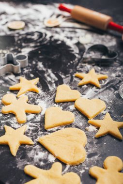 Noel için un ve çiğ zencefilli bisküvilerle dolu bir masanın dikey fotoğrafı..