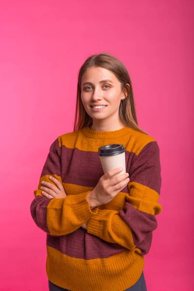 Pionowe Zdjęcie Kobiety Uśmiechniętej Aparatu Trzymającej Filiżankę Kawy Różowym Tle — Zdjęcie stockowe