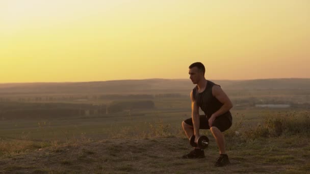 Beelden van jonge sporters die buiten trainen bij zonsondergang met halters — Stockvideo