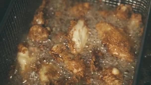 Filmaufnahmen von knusprig gebratenen Chicken Wings, kochendem Öl — Stockvideo