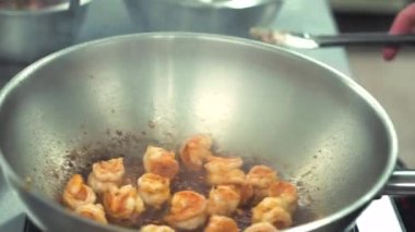 Çinli aşçının tavada kızarmış karides hazırladığı görüntüler.