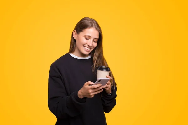 Sorrindo Jovem Está Digitando Telefone Enquanto Desfruta Dela Para Café — Fotografia de Stock