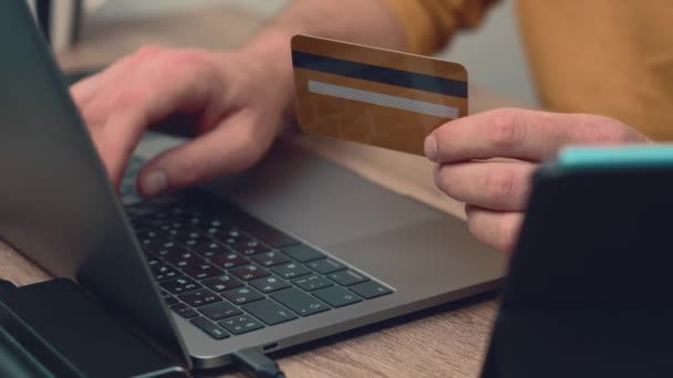 Закрыть видео, где человек покупает что-то онлайн с помощью кредитной карты на ноутбуке — стоковое видео
