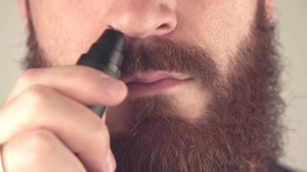 Закрыть кадры, где мужчина вынимает волосы из носа тримером — стоковое видео