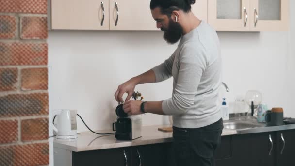 Filmación del joven barbudo haciendo un café con la máquina de café cápsula en la cocina de la oficina — Vídeo de stock