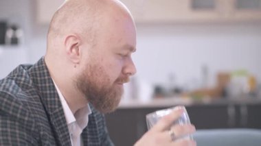 Ofiste bir fincan kahve içen sakallı genç adamın görüntülerini kapatın.