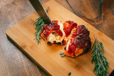 Lezzetli pastayı krema ve meyve reçeli ile ahşap masaya kapat..