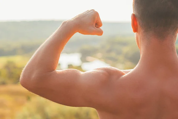 Foto de cerca del brazo musculoso del hombre al atardecer — Foto de Stock