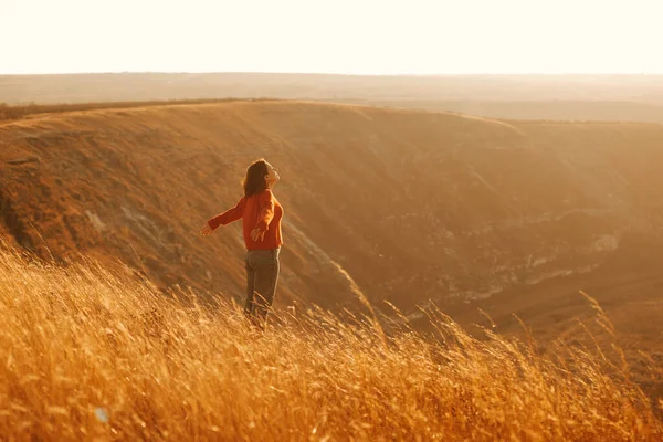 Фото молодой женщины, загорающей на холме с прекрасным видом — стоковое фото