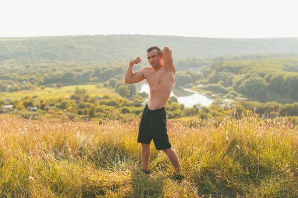 Una bonita foto de un hombre musculoso en una colina en verano — Foto de Stock
