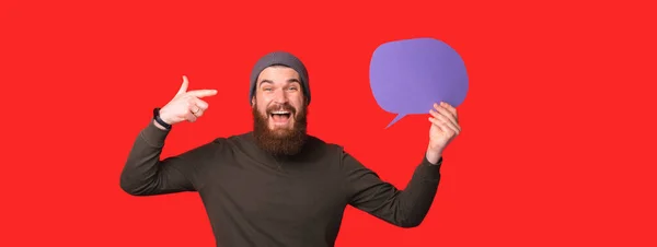 Banner tamanho foto de homem surpreso com barba apontando para bolha discurso em branco — Fotografia de Stock