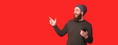 Akıllı telefon kullanan ve işaret eden heyecanlı adam