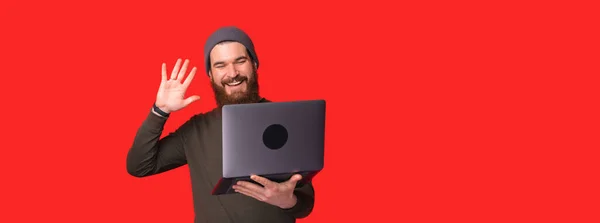 Sorrindo homem acenando a mão para laptop durante a reunião online — Fotografia de Stock