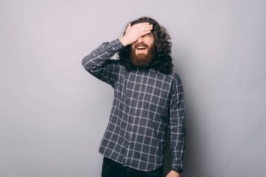 İnançsızlıkla alnına tokat atan unutkan adam.