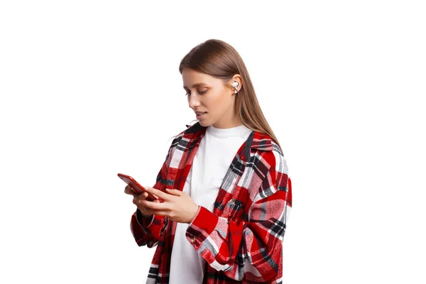 Portrait of a young woman holding smartphone over white background — Fotografia de Stock
