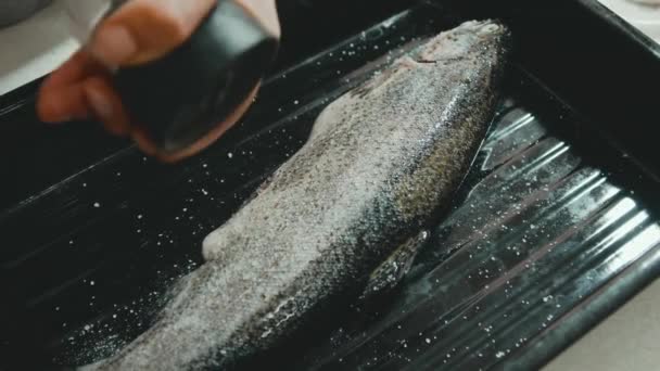 Filmaufnahmen einer Frau, die frischen Fisch zum Kochen zubereitet — Stockvideo