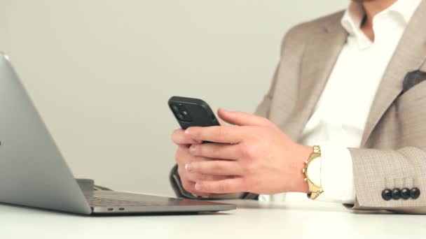 Fermer les images de l'homme assis occasionnellement à la table du bureau et en utilisant un smartphone — Video