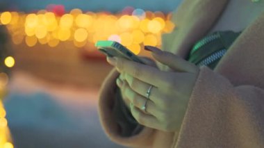 Açık alanda akıllı telefondan yazı yazan kadının yavaş çekim görüntülerini kapat.